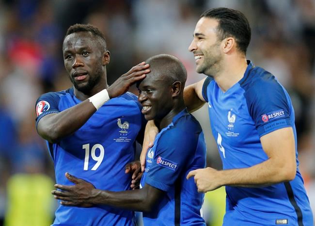 France's Bacary Sagna N'Golo Kante and Adil Rami from left celebrate after winning 2-0 during the Euro 2016 semifinal soccer match between Germany and France at the Velodrome stadium in Marseille France Thursday