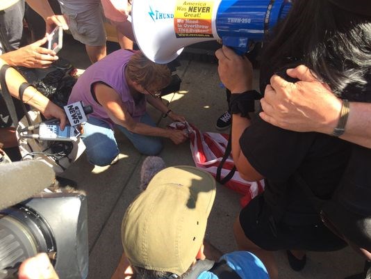 Protesters attempted to burn a flag outside Quicken Loans Arena Wednesday