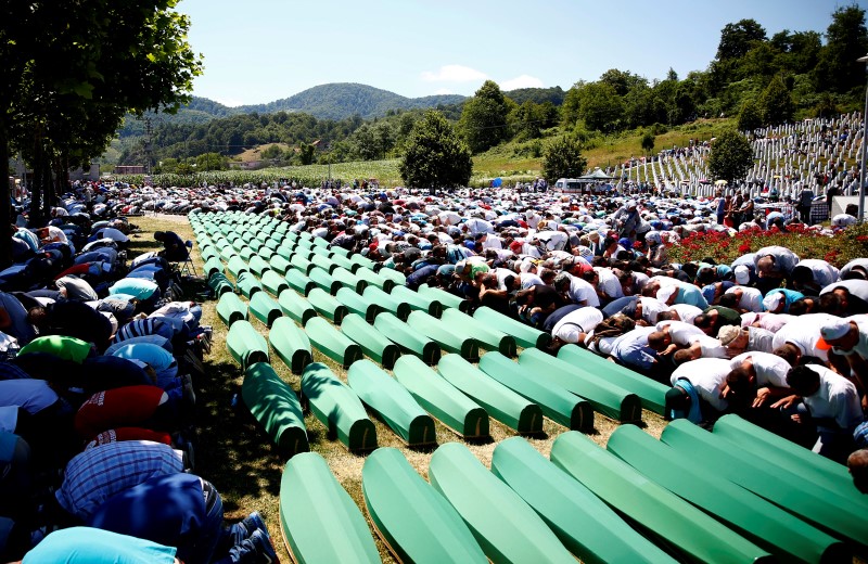 ReutersMuslim men prayed in front of coffins during a mass funeral in Potocari near Srebrenica