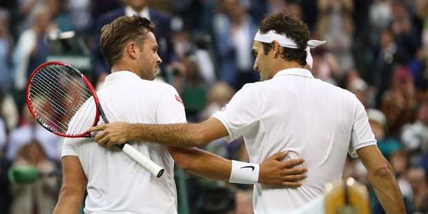 Roger Federer embraces Britain's Marcus Willis at the net after Federer won their men's singles second round Wimbledon match