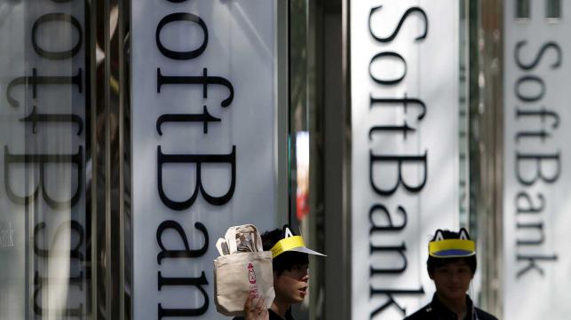 Shop employees of Soft Bank Corp work outside its branch in Tokyo