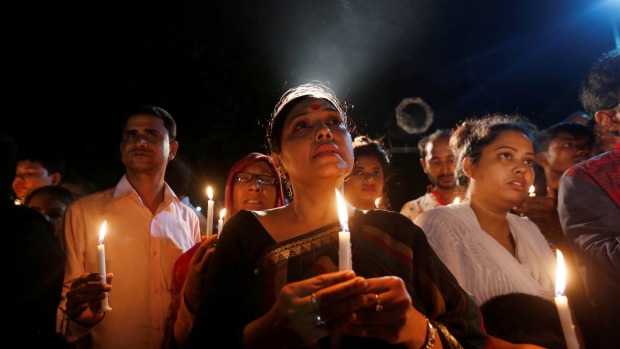 People attend a candle light vigil for the victims of the attack on the Holey Artisan Bakery and the O'Kitchen