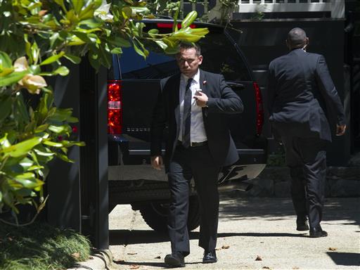 Secret Service stand guard around a Secret Service vehicle after it arrived at the home of Democratic presidential candidate Hillary Clinton in Washington Saturday