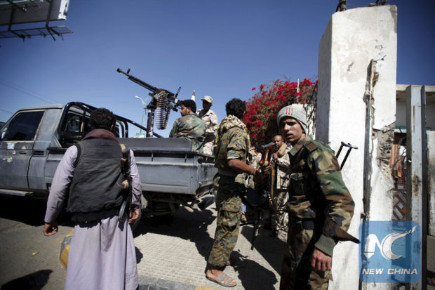 Houthi militants stand guard near a gathering