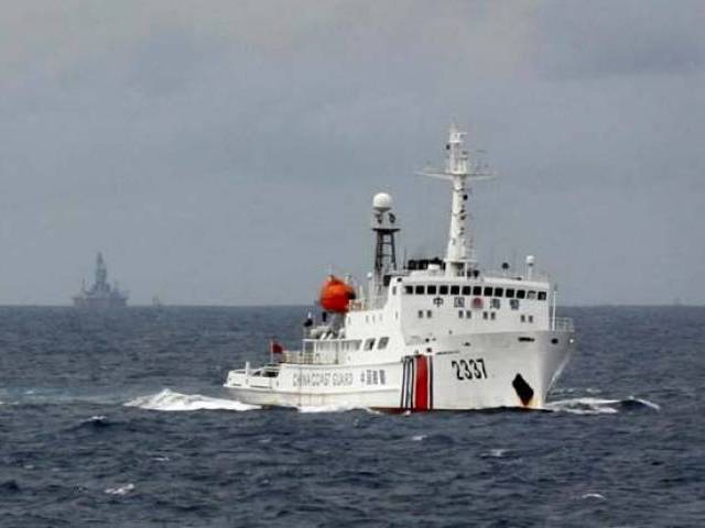 A Chinese Coast Guard vessel passes near the Chinese oil rig Haiyang Shi You 981 in the South China Sea about 210 km from the coast of Vietnam