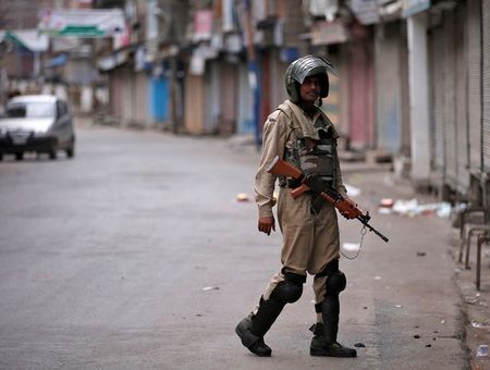 An Indian policeman stands guard in a deserted street during a curfew in Srinagar