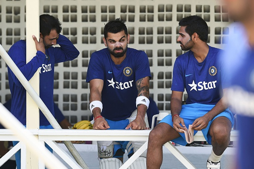 Virat Kohli chats with his teammates during a practice session