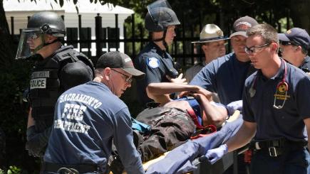 Paramedics tend to a stabbing victim after members of right-wing extremists groups holding a rally outside the California state Capitol building in Sacramento clashed with counter-protesters