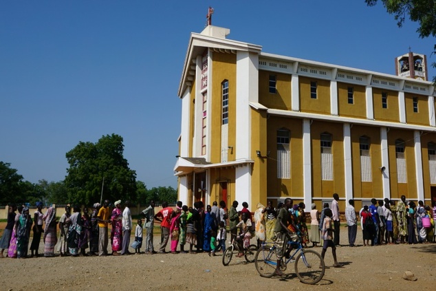 South Sudanese civilians in the capital queue for mosquito nets and blankets outside the St Theresa Roman Catholic Cathedral in Juba