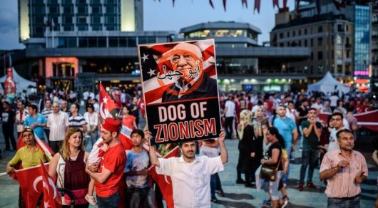 A Pro Erdogan supporter holds a portrait of US-based cleric Fethullah Gulen during a rally against the military coup on Taksim square in Istanbul