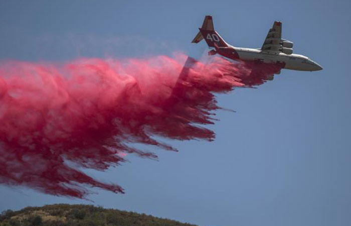 A firefighting air tanker drops fire retardant on the Sand Fire in Placerita Canyon in Santa Clarita California on Monday. — AFP