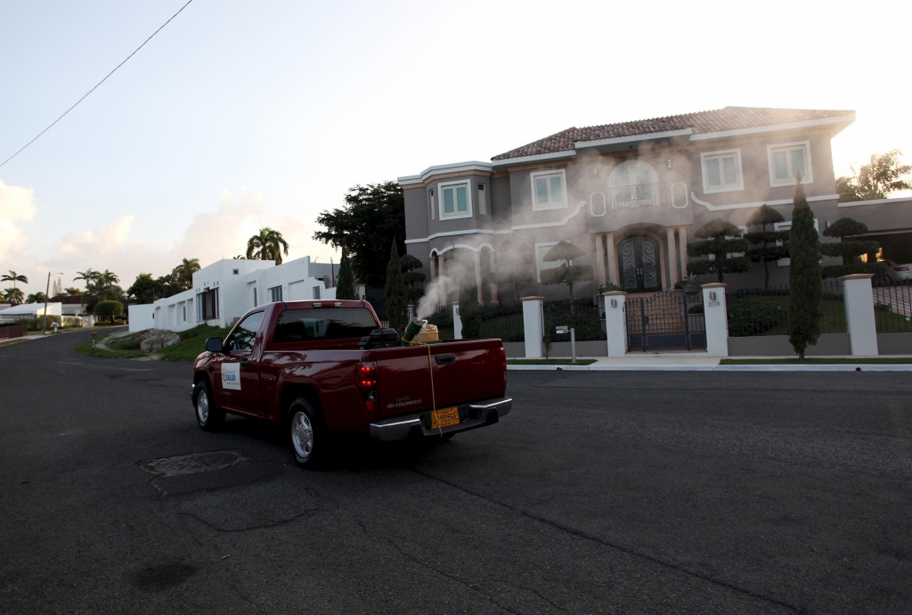 A health department pickup truck sprays insecticide against mosquitoes in a San Juan Puerto Rico neighborhood in January