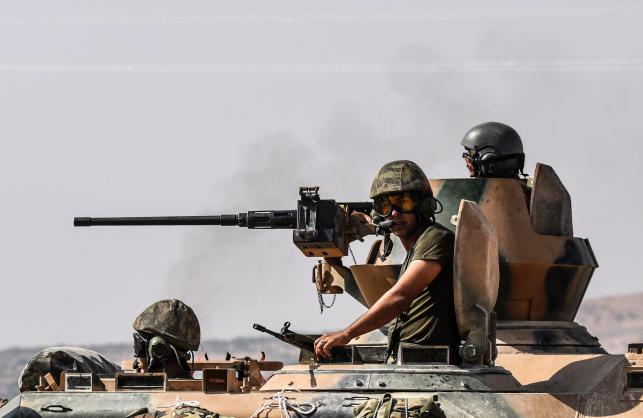 Turkish soldiers seat in a tank driving to Syria from the Turkish Syrian border city of Karkamis in the southern region of Gaziantep on Saturday