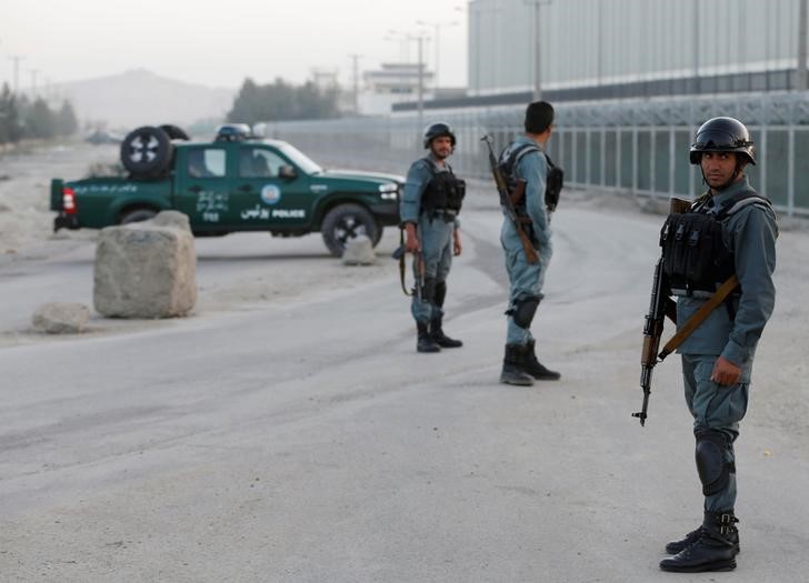 Afghan policemen keep watch near the site of a bomb blast in Kabul Afghanistan