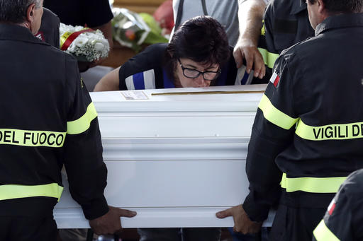 A woman kisses the coffin of 9-year-old Giulia Rinaldo as it is carried outside the gymnasium at the end of the state funeral service in Ascoli Piceno Italy Saturday Aug. 27 2016. Funerals for some victims took place