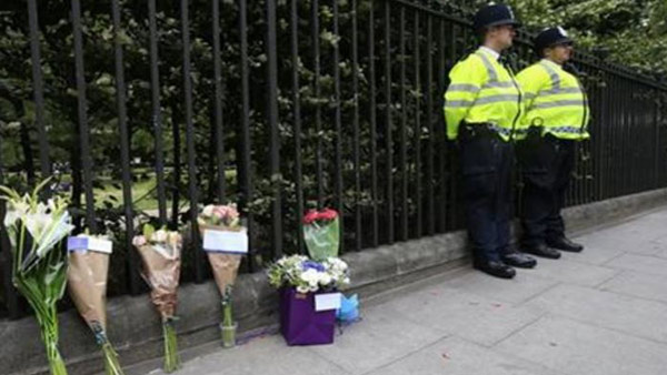 Floral tributes rest against railings Thursday Aug. 4 2016 near the scene of a fatal stabbing on Wednesday night in Russell Square London. London police say they have found no signs of radicalization in a knife attack which killed an American woman and