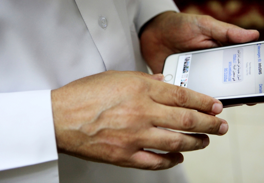 Human rights activist Ahmed Mansoor shows Associated Press journalists a screenshot of a spoof text message he received in Ajman United Arab Emirates on Thursday Aug. 25 2016. Mansoor was recently targeted by spyware that can hack into Apple's iP