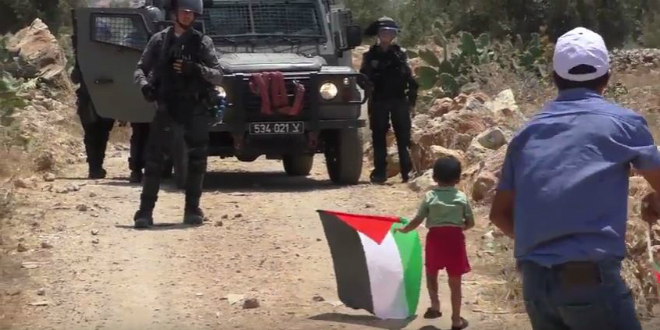 Arab boy approaches IDF jeep in Ni'lin