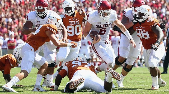 DALLAS TX- OCTOBER 10 Baker Mayfield #6 of the Oklahoma Sooners carries the ball against Chris Nelson #97 of the Texas Longhorns in the second quarter during the AT&T Red River Showdown at the Cotton Bowl