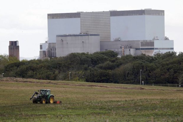 A tractor mows a field on the site where EDF Energy's Hinkley Point C nuclear power station will be constructed in Bridgwater southwest England