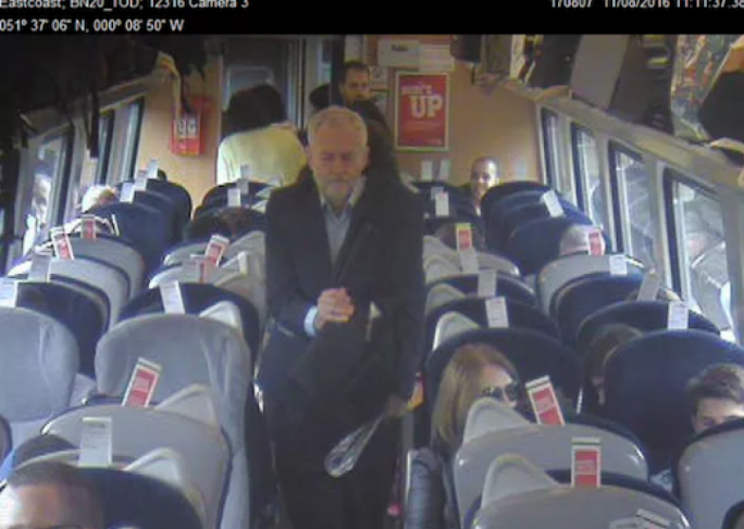 CCTV footage purportedly shows Jeremy Corbyn walking past rows of empty seats to sit on the floor of a train