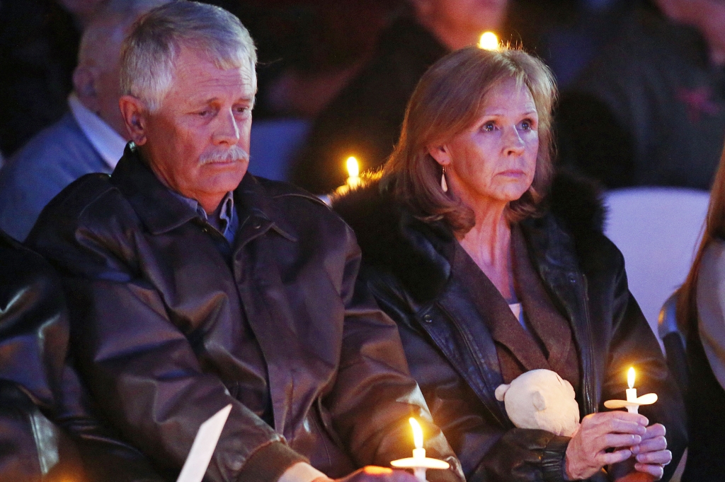 Carl and Marsha Mueller hold candles at a memorial in honor of their daughter Kayla