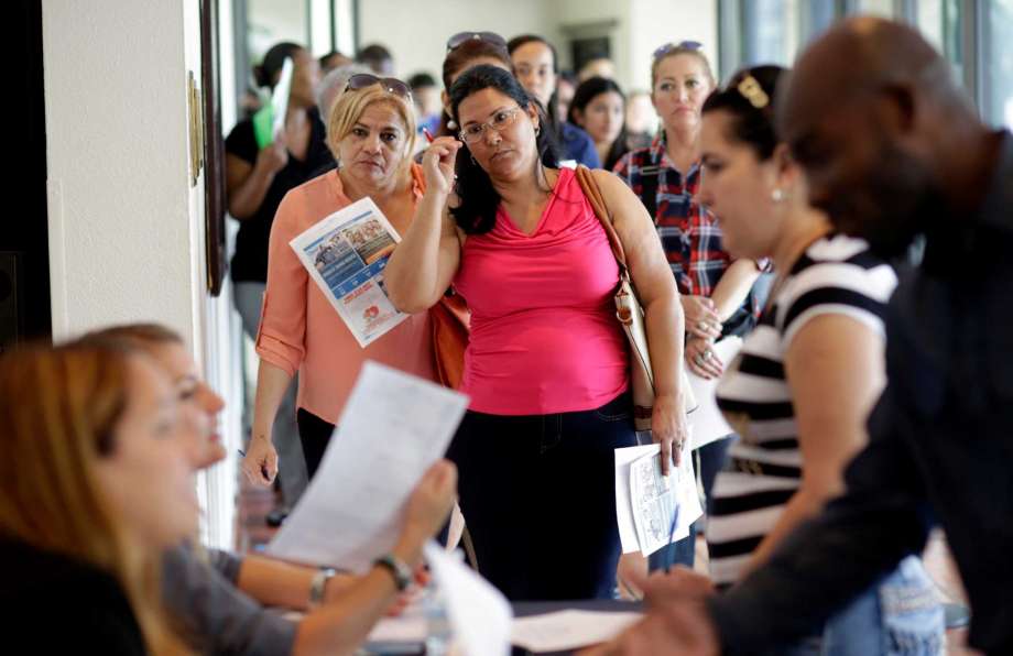 Reina Borges left stands in line to apply for a job with Aldi at a job fair in Miami Lakes Fla. On Friday Aug. 5 the Labor Department issues its jobs report for July