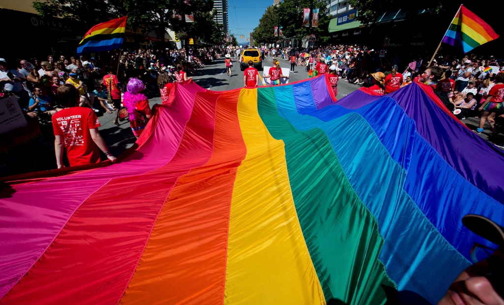 A rainbow flag is held by marchers in the annual Pride parade in Vancouver's West End