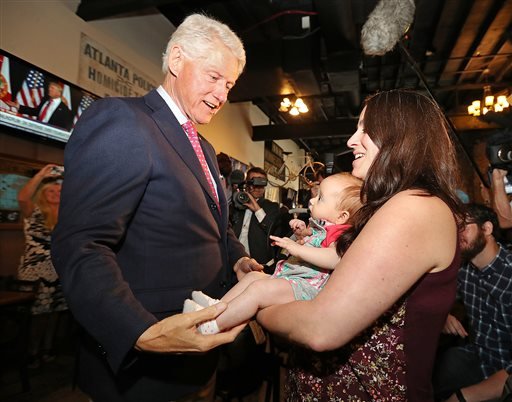 Former President Bill Clinton left says hello to Megan Bartlett of Decatur Ga. and her 3-month-old daughter Hannah Rice as he works the crowd at historic Manuel's Tavern Wednesday Aug. 24 2016 during a stop in Atlanta. (Curtis Compton  Atlanta Jo