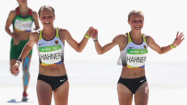 Anna Hahner left and her sister Lisa Hahner reacts as they approach the finish line during the women's marathon in Rio