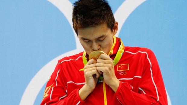 Controversial Chinese swimmer Sun Yang kisses his gold medal after winning the men's 200m freestyle final