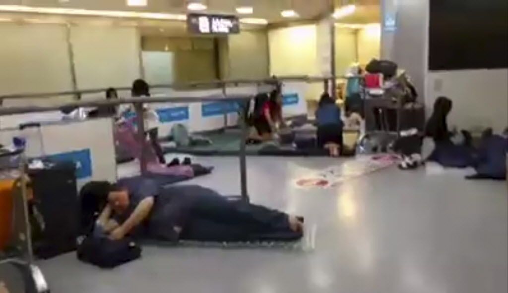 In this image made from video stranded passengers lay on air mattresses at the Narita international airport in Narita outside Tokyo early Tuesday Aug. 9 2016