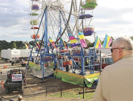 Law enforcement cordon off the area surrounding the Ferris wheel Monday Aug. 8 2016 after three people fell from the ride during a county fair in Greenville Tenn. Baileyton police Officer Kenneth Bitner is visible at right. Police say one of three peo