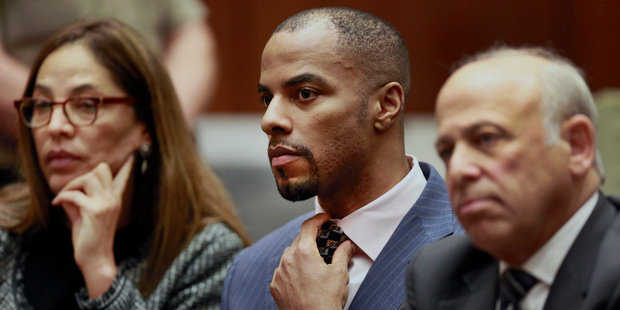 Former NFL star Darren Sharper centre has been sentenced to 18 years in prison for drugging and raping up to 16 women