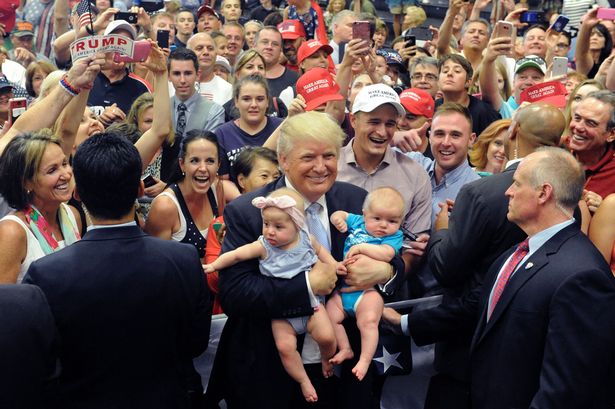 US Republican Presidential Candidate Donald Trump holds two babies after his Town Hall address at the Gallogly Events Center in Colorado Springs Colorado