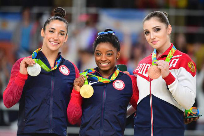 Alexandra Raisman and Simone Biles of the US and Russia’s Aliya Mustafina celebrate on the podium of the individual all around final of the artistic gymnastics at the Olympic Arena in Rio de Janeiro Thursday. — AFP