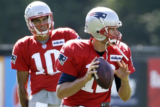 New England Patriots quarterback Tom Brady gets set to throw a pass as quarterback Jimmy Garoppolo watches during NFL football training camp in Foxborough Mass. This is one unusual summer for