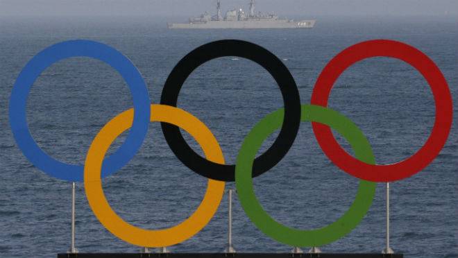 A military ship makes its way by Olympic rings placed at the Copacabana beach volleyball arena prior to the 2016 Summer Olympics in Rio de Janeiro Brazil Tuesday Aug. 2 2016