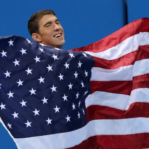 Michael Phelps walks with his national flag during the medal ceremony for the men's 4 x 100-meter medley relay final during the swimming competitions at the 2016 Summer Olympics Sunday Aug. 14 2016 in Rio de Janeiro B