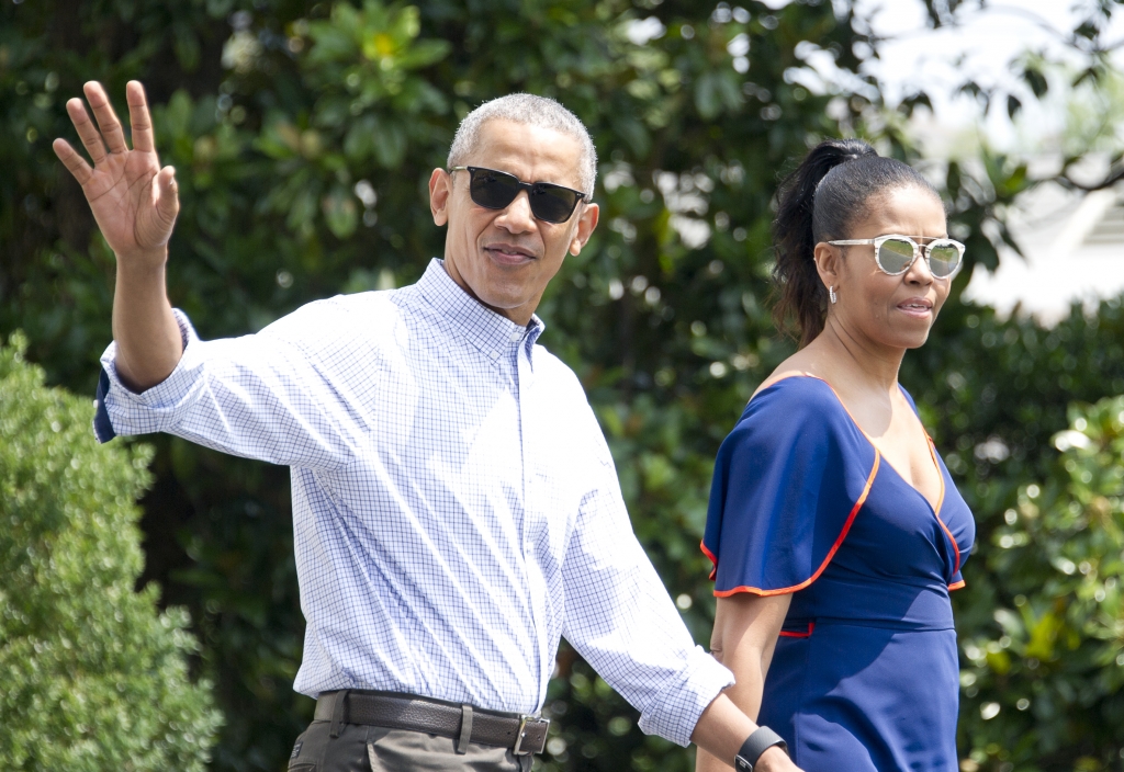 WASHINGTON DC- AUGUST 6  U.S. President Barack Obama waves to the assembled press as he and first lady Michelle Obama depart the White House