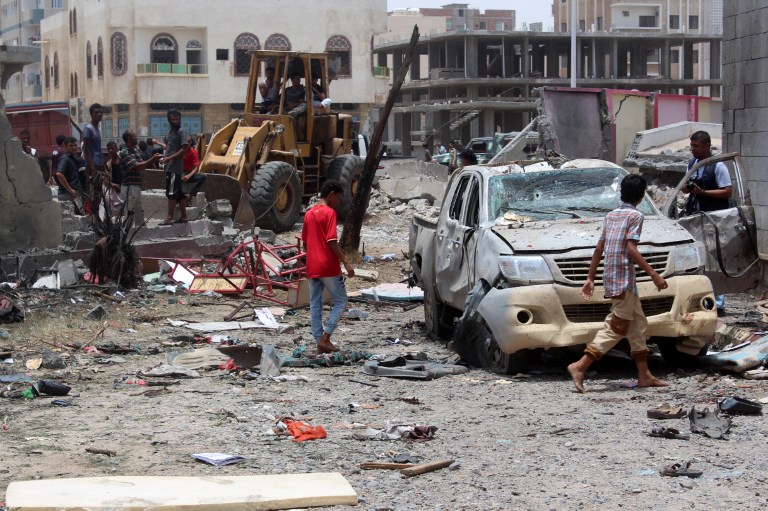 Yemenis inspect the site of a suicide car bombing claimed by the Islamic State group