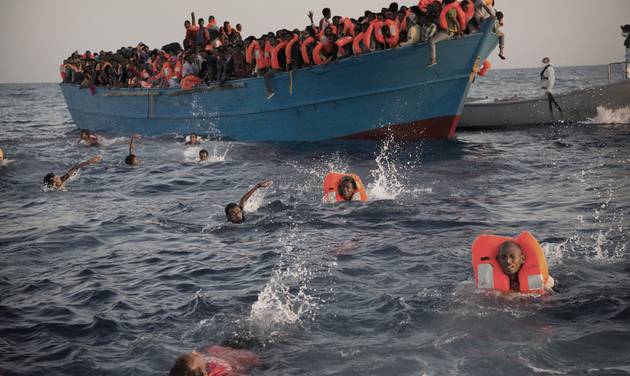 Migrants most of them from Eritrea jump into the water from a crowded wooden boat as they are helped by members of an NGO during a rescue operation at the Mediterranean sea about 13 miles north of Sabratha Libya Monday Aug. 29 2016. Thousands of