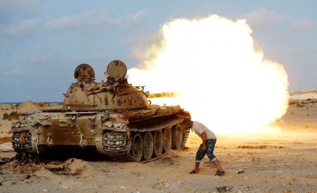 A fighter of Libyan forces allied with the UN-backed government fires a shell with Soviet made T-55 tank at Islamic State fighters in Sirte Libya