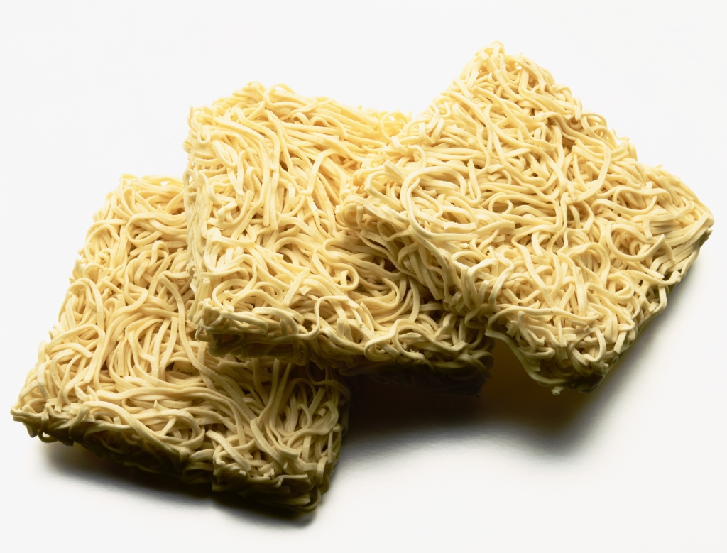 Dry egg noodles against white background close-up