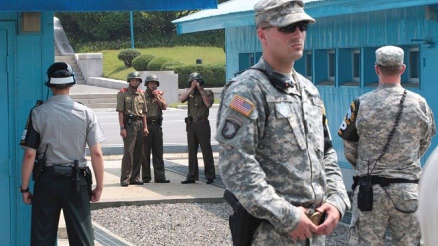 North Korean army soldiers watch the south side while a South Korean and United States Army soldiers stand guard at the border villages of Panmunjom in Paju South Korea