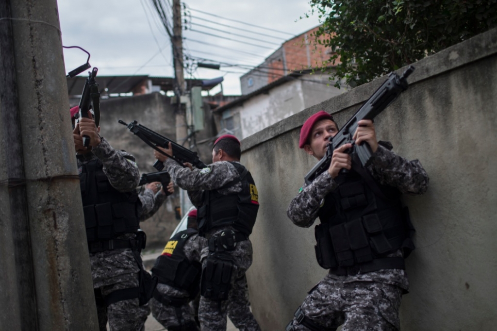 Brazil's national security force officers aim their weapons during a police operation in search for criminals in Vila do Joao part of the Mare complex of slums during the 2016 Summer Olympics in Rio de Janeiro Brazil Thursday Aug. 11 2016. A police