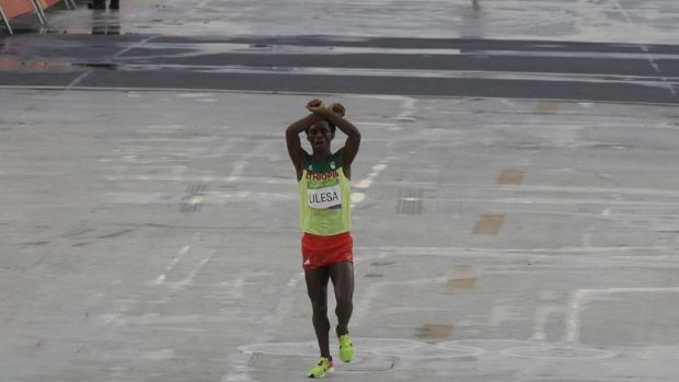 Moment of protest Ethiopia's Feyisa Lilesa crosses his arms as he crosses the finish line