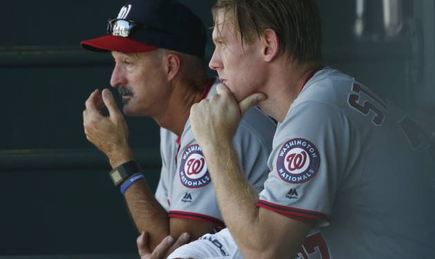 Washington Nationals starting pitcher Stephen Strasburg right sits with pitching coach Mike Maddux after Strasburg faced 11 batters before retiring the Colorado Rockies in the first inning of a baseball game Wednesday Aug. 17 2016 in Denver. (AP