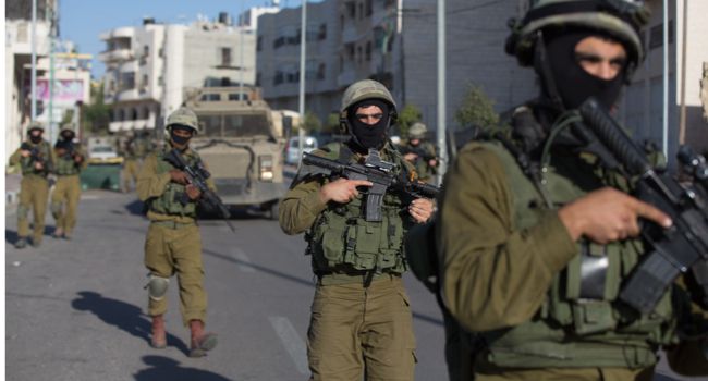 Searching Israeli soldiers from a special army unit take part in a search operation for three Israeli teenagers believed kidnapped by Palestinian militants