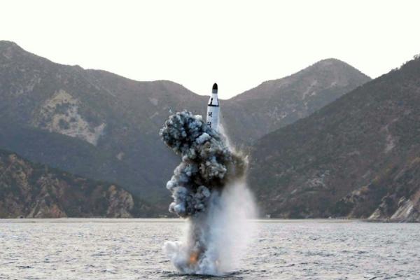 FILE- Image released by KCNA showing the test-fire of a strategic submarine ballistic missile at an undisclosed location in North Korea